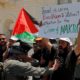 Seorang demonstran Palestina memegang plakat selama protes yang menandai ulang tahun ke-71 Hari 'Nakba', atau 'bencana', dan terhadap Eurovision Song Contest yang diselenggarakan oleh Israel, di Betlehem di Tepi Barat yang diduduki Israel 15 Mei 2019. (Foto: Reuters/Mussa Qawasma)