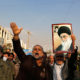 Demonstran pro-pemerintah memegang poster pemimpin tertinggi Iran, Ayatollah Ali Khamenei (kanan), dan pendiri Republik Islam Iran, Ayatollah Ruhollah Khomeini