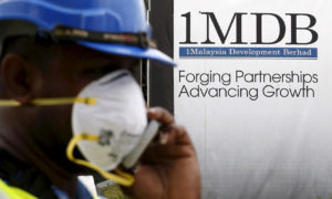 Seorang pekerja konstruksi berbicara di telepon di depan papan iklan 1Malaysia Development Berhad (1MDB) di pembangunan Tun Razak Exchange di Kuala Lumpur, Malaysia, 3 Februari 2016. (Foto: REUTERS/Olivia Harris/File Photo)