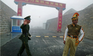 Seorang tentara China (L) di samping seorang tentara India di perbatasan Nathu La yang melintasi antara India dan China di negara bagian Sikkim di timur laut India