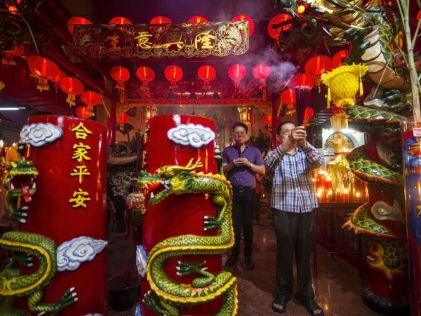 Sebuah pemuja etnis Indonesia-Cina membakar dupa di sebuah kuil di Surabaya, timur pulau Jawa, pada malam Tahun Baru Imlek. (JUNI KRISWANTO / AFP / Getty Images)