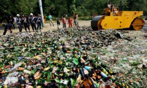 Perwira Indonesia menghancurkan minuman beralkohol yang disita pada bulan suci Ramadhan. Foto: EPA