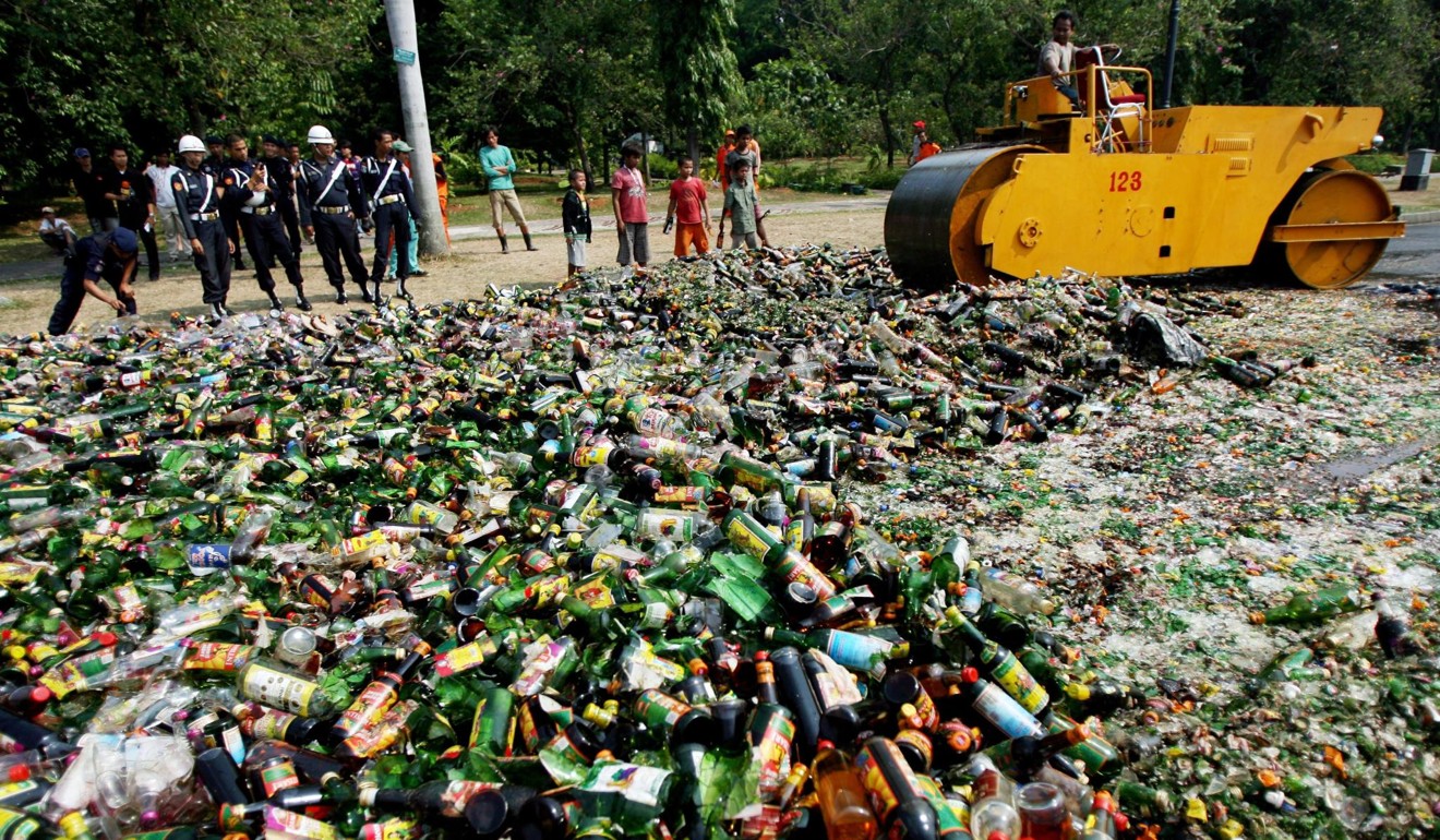 Perwira Indonesia menghancurkan minuman beralkohol yang disita pada bulan suci Ramadhan. Foto: EPA