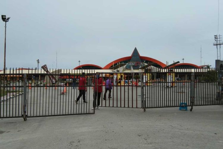 Petugas Bandar Udara Internasional Sentani di Kabupaten Jayapura, Provinsi Papua menutup pagar sebagai tanda aktivitas di lokasi tersebut dihentikan untuk mencegah penyebaran virus corona baru, Papua, Kamis, 26 Maret 2020.